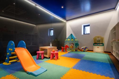 a play room with a slide and a playground at The Yama Hotel Phuket in Kata Beach