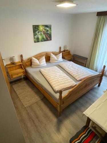 Un dormitorio con una gran cama de madera con almohadas blancas. en Haus Grünstein, en Biberwier
