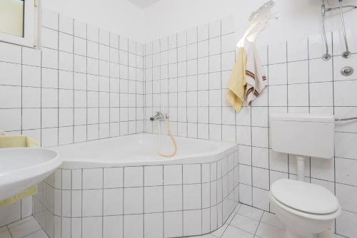 biała łazienka z toaletą i umywalką w obiekcie Apartments with a parking space Zuljana, Peljesac - 4574 w mieście Žuljana