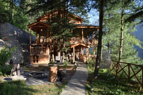 a log cabin in the woods with a walkway in front at Kudrat - A Boutique Homestay- Tirthan Valley in Banjār