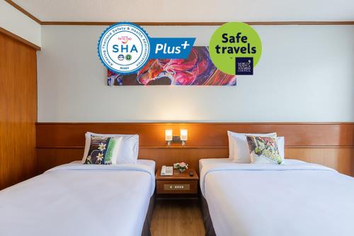 two beds sitting next to each other in a room at Royal Phuket City Hotel - SHA Extra Plus in Phuket Town