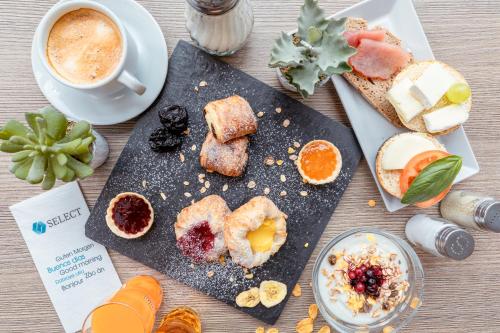 uma mesa com um prato de comida e uma chávena de café em Select Hotel Handelshof Essen em Essen