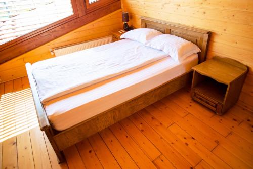 een bed in een kamer met een houten vloer bij Sat de vacanta Ciprian Porumbescu in Suceava