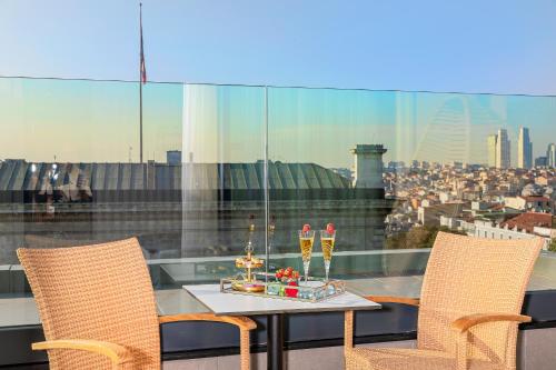 a table and two chairs on a balcony with a view at Mukarnas Pera Hotel in Istanbul