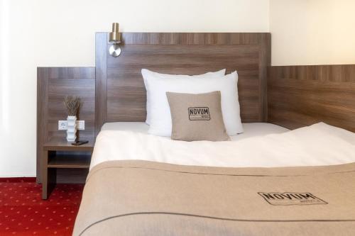 a bedroom with a large bed with a wooden headboard at Hotel Leonet in Cologne