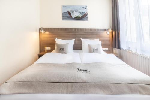 a bed with white sheets and pillows in a bedroom at Hotel Leonet in Cologne