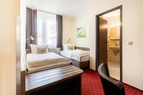 a hotel room with two beds and a mirror at Novum Hotel Leonet Köln Altstadt in Cologne