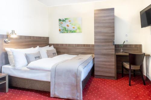 a hotel room with a bed and a desk at Hotel Leonet in Cologne