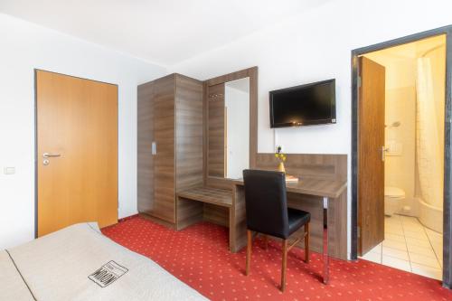 a hotel room with a desk and a television at Hotel Leonet in Cologne