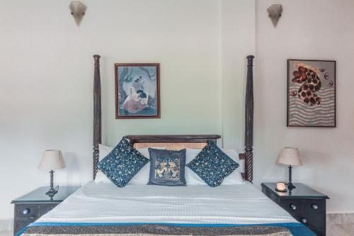 a bedroom with a bed with blue pillows at Beachfront mansion with pool in Calangute