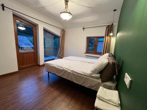 a bedroom with a bed and a green wall at Dilijan Mountain View, 3 bedroom house in Dilijan
