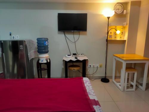 a living room with a tv on the wall at The City Sky Studio MDNPRO APT Springlake SMB in Rawabugel
