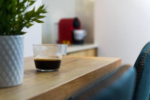 a cup of coffee sitting on a wooden table at Musrara #6 in Jerusalem