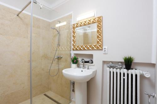 Un baño con lavabo y ducha en Grand Phillip Cismigiu Park Downtown Bucharest, en Bucarest