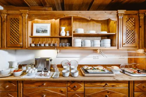 una cocina con armarios de madera y una barra con platos en Seehotel Berau en St. Wolfgang