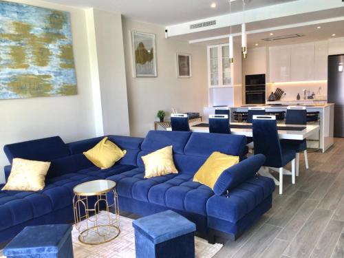 un soggiorno con divano blu e una cucina di Luxury Apartment Tomaso - The View Fuengirola a Fuengirola