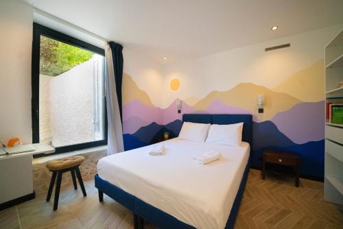 a bedroom with a bed with a mountain mural on the wall at Roma Divine home cinéma et jardin in Nîmes