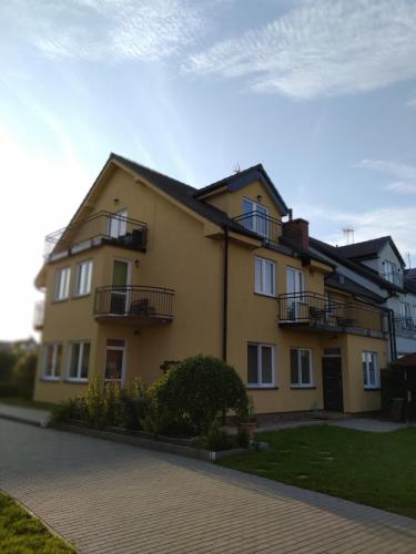 una casa amarilla con balcones en un lateral. en Baltazar, en Łeba