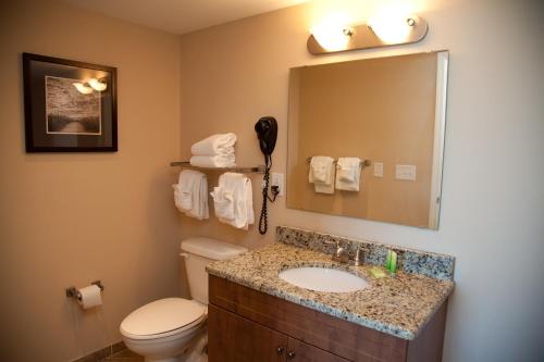 a bathroom with a sink and a toilet and a mirror at Towers at North Myrtle Beach in Myrtle Beach