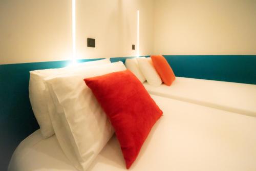 two red and white pillows sitting on a couch at Roma Divine home cinéma et jardin in Nîmes