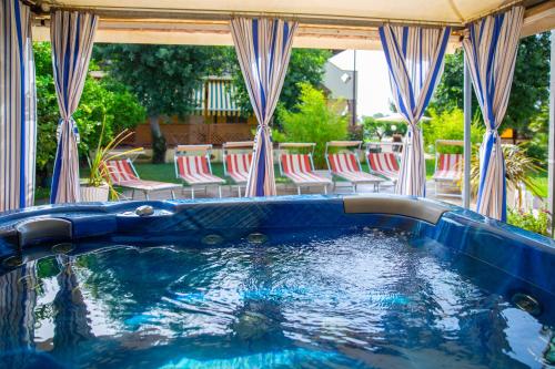 a pool with red and white chairs in a yard at I Lecci Guesthouse in San Felice Circeo