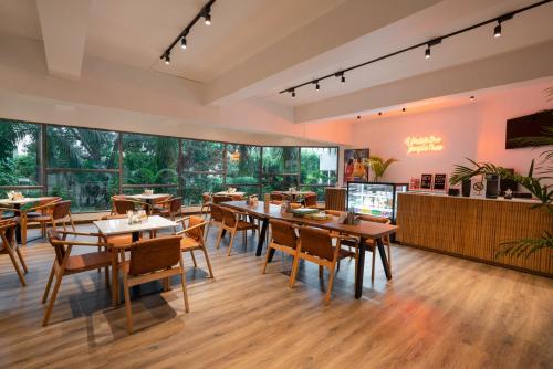 a restaurant with tables and chairs and large windows at Rajdarshan - A Lake View Hotel in Udaipur in Udaipur