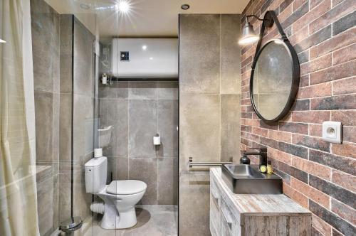 ein Badezimmer mit einem WC, einem Waschbecken und einem Spiegel in der Unterkunft Bel appartement idéal pour 4 personnes, 2 chambres in Paris