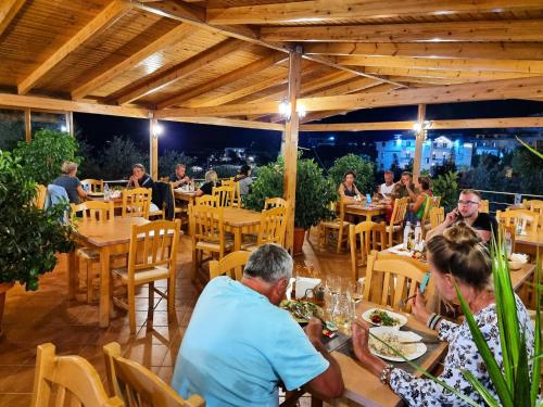 eine Gruppe von Personen, die in einem Restaurant an Tischen sitzen in der Unterkunft Hotel Lula Ksamil in Ksamil
