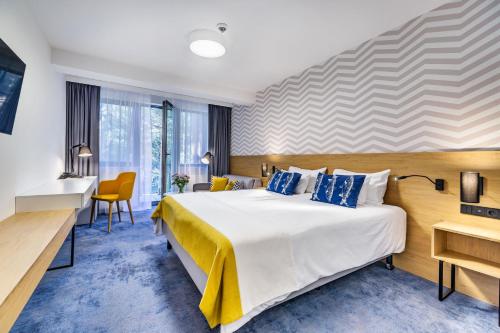 a hotel room with a large bed and a desk at Best Western Hotel Jurata in Jurata