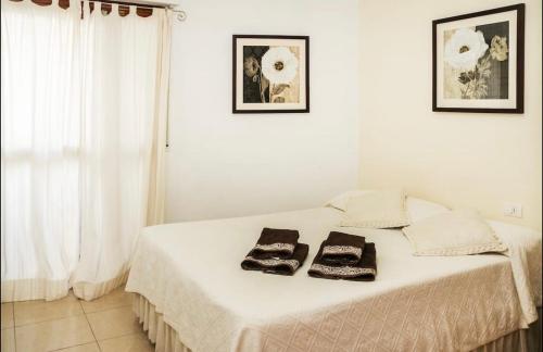 Una cama blanca con dos toallas encima. en Apartamento Atlantida, en Santa Cruz de Tenerife