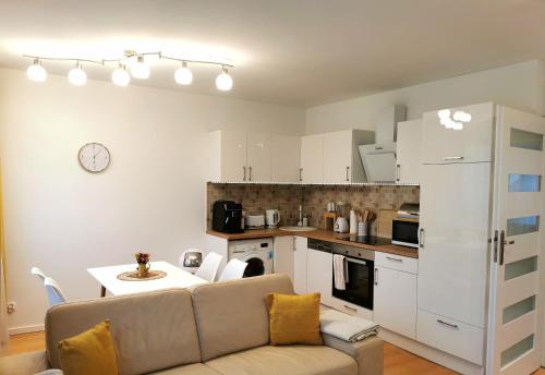 sala de estar con sofá y cocina en PARKIDYLLE (Familien Apartment, 3 Zimmer,2 Schlafzimmer,Balkon), en Świnoujście