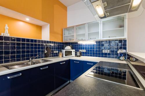 uma cozinha azul e branca com um lavatório e um micro-ondas em Rataskaevu 6 Apartment em Talin