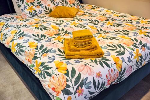 a bed with a yellow towel and flowers on it at Studio next to Skinny Bridge near Rembrandtsquare in Amsterdam