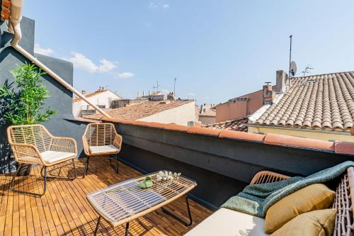 un balcon avec des chaises et des tables sur un toit dans l'établissement LOFT EN VILLE - Duplex Terrasse coeur historique avec vue dégagée & Parking souterrain Offert, à La Ciotat