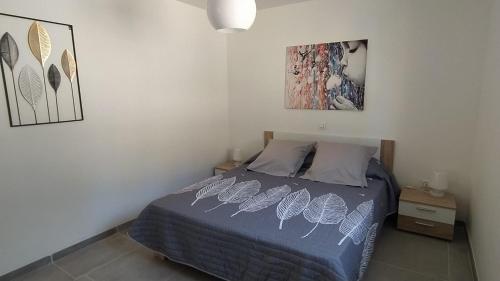 een slaapkamer met een bed met een blauw dekbed bij Les Bosquets JOLY in Montauroux