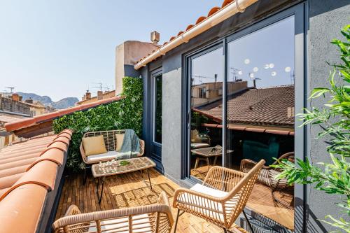 d'une terrasse avec des chaises et des tables sur un balcon. dans l'établissement LOFT EN VILLE - Duplex Terrasse coeur historique avec vue dégagée & Parking souterrain Offert, à La Ciotat
