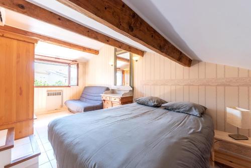 a bedroom with a bed and a chair at MAISON COSY avec petite piscine in Six-Fours-les-Plages