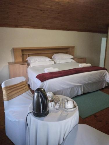 a hotel room with two beds and a table and chairs at Hamba Kancane Ma-Africa Guest House in Graskop