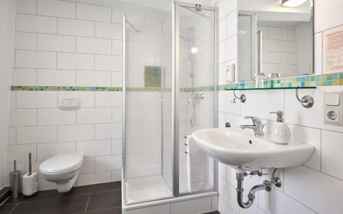 a white bathroom with a sink and a shower at Pension-Ristorante Ventura ehemals Reinhards Pension in Hornburg
