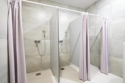 W łazience znajduje się prysznic ze szklanymi drzwiami. w obiekcie Motel ROKO w mieście Szczecińska