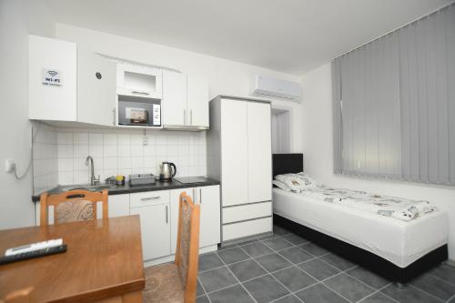a small kitchen with a bed and a table at Relax Apartmani Rooms in Kladovo