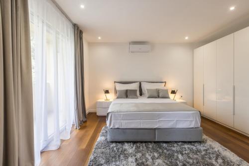 een slaapkamer met een bed en een groot raam bij Apartment FORTUNA in Split