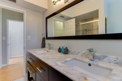 a bathroom with two sinks and a large mirror at Woodland Hills Charmer in Los Angeles