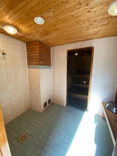 a room with a tile floor and a wooden ceiling at Kooli talu puhkemaja in Valingu