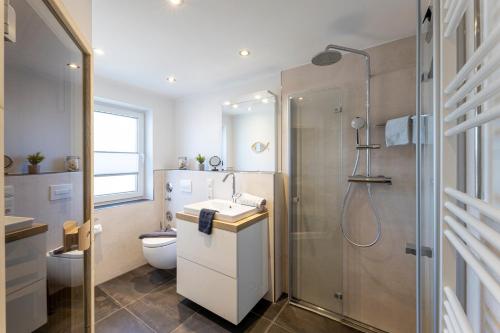 a bathroom with a shower and a sink and a toilet at Sommerwind Borkum Alfonso Wohnung 3 - Urlaub mit Hund in Borkum