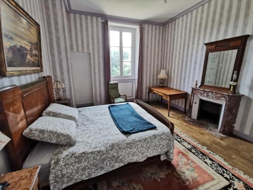 a bedroom with a bed and a fireplace at Château de Launay Guen in Plémet
