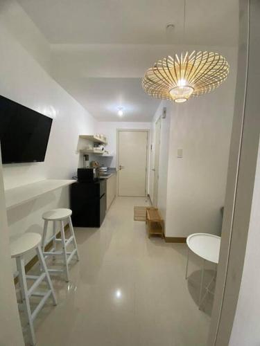 - un salon avec deux chaises et un lustre dans l'établissement 1BR unit in South Residence Las Pinas with Wifi & Netflix, à Manille