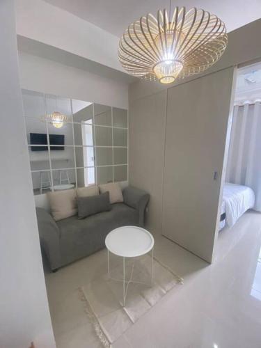 a living room with a couch and a table at 1BR unit in South Residence Las Pinas with Wifi & Netflix in Manila