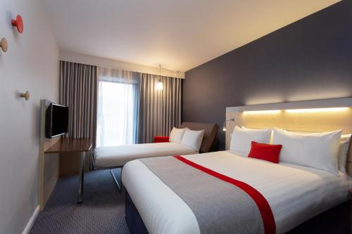 a hotel room with two beds and a television at Holiday Inn Express Cheltenham Town Centre, an IHG Hotel in Cheltenham