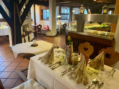 a dining room with two tables with white tablecloths at Hotel und Restaurant Post Prienbach in Stubenberg